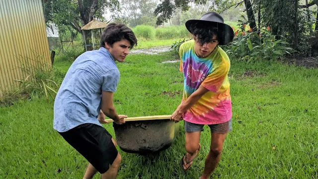 Joseph Baronio and Nathaniel Kelly dragging a bath through the rain